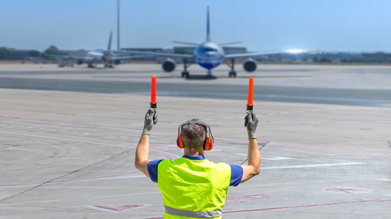 What Does It Mean When An Airline’s Ground Crew Member Waves Those Lights Around?